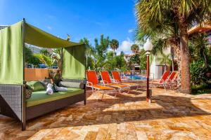 a patio with a couch and chairs next to a pool at Ocean Beach Club in Fort Lauderdale