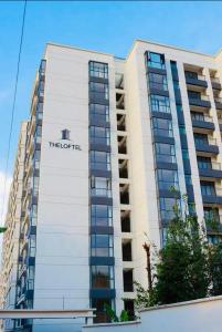 a tall white building with the hotel sign on it at Nyvin Homes at The Loftel in Ruaka