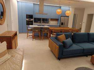 a living room with a blue couch and a kitchen at Blue Aura Beach villa Larnaca in Pervolia