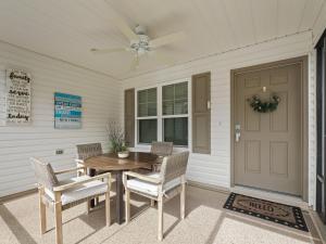 a porch with a table and chairs and a door at 5682 Z6 VILLAGE OF DESOTO by REMAX Premier in The Villages