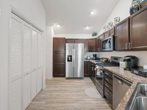 a kitchen with wooden cabinets and a stainless steel refrigerator at 5682 Z6 VILLAGE OF DESOTO by REMAX Premier in The Villages