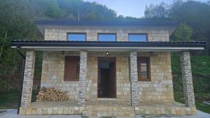 a small brick house with a pile of fire wood at Panorama in Plav