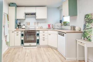 a white kitchen with white cabinets and appliances at Ferienwohnung Nawrot in Bad Saulgau