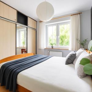 a bedroom with a large white bed and two windows at Willa Ada & Apartments in Karpacz