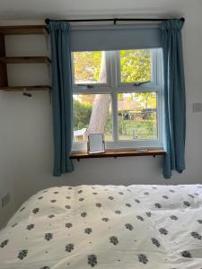 a bedroom with a bed and a window at Tiny home in Grade 1 listed church garden in Dunham