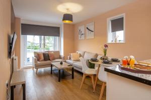 ein Wohnzimmer mit Sofa und Tisch in der Unterkunft The Monument Apartment, 2 Bedrooms, 2 Bathrooms, Private Balcony, Open Plan kitchen, Recently Renovated, Code-Access Development, Free Multi Car Park, Ideal Location in Oxford