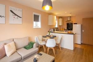 ein Wohnzimmer mit Couch und Tisch und eine Küche in der Unterkunft The Monument Apartment, 2 Bedrooms, 2 Bathrooms, Private Balcony, Open Plan kitchen, Recently Renovated, Code-Access Development, Free Multi Car Park, Ideal Location in Oxford