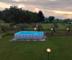 a large swimming pool in a yard with a field at B&B Hill Ranch in Camerano