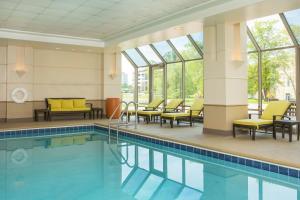 a pool in a hotel with yellow chairs and windows at Sheraton Suites Chicago Elk Grove in Elk Grove Village