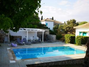 a swimming pool in the backyard of a house at The Iconpainter Peroulia Villa in Kómboi