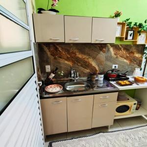 a kitchen with a sink and a counter at Quarto mobiliado com banheiro privativo em uma casa in Mairiporã
