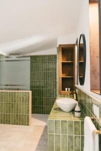 a bathroom with a sink and green tiles at Apartamentos Turísticos La Teja in Arroyo del Ojanco