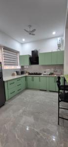 an empty kitchen with green cabinets and a ceiling at Buraans in Dehradun