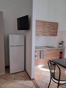 a kitchen with a refrigerator and a table with a chair at B&B Manzoni 2 in Neviano +2 photos