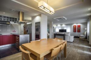 a kitchen and dining room with a wooden table in a room at Holiday Villa Benmar in Castellón de la Plana