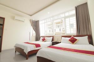 ブンタウにあるThảo Nguyên Hotelの窓のある部屋にベッドが2つある