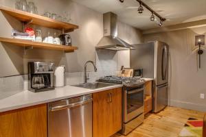 Una cocina con electrodomésticos de acero inoxidable y gabinetes de madera. en Comfy Family Retreat for 4 in DT Walk to Broadway, en Nashville