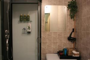 a bathroom with a shower with a sink and a mirror at Mazais stūrītis pie Pērkones kanāla in Liepāja +17 photos