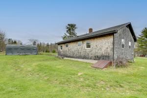 an old brick building in a field next to a house at Day Trip to Acadia Quiet Coastal Maine Escape in Harrington