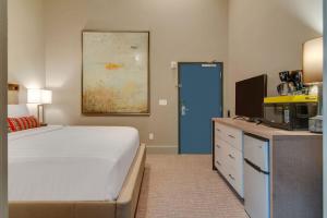 a bedroom with a bed and a desk with a tv at Quaint Retreat for 2 Heart of DT Near Broadway in Nashville