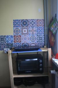 a microwave sitting on a stand in a room at Mazais stūrītis pie Pērkones kanāla in Liepāja
