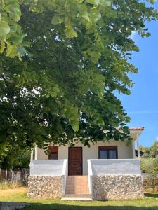 a small house with a wooden door under a tree at Casa Mareal in Paliouri