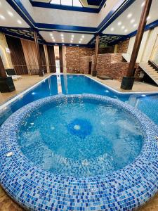 Una gran piscina con azulejos azules en un edificio. en EMIRS GARDEN Residence, en Bukhara