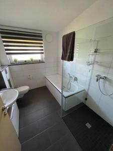 a bathroom with a tub and a toilet and a sink at Ferienwohnung Meiwes in Hövelhof +33 photos