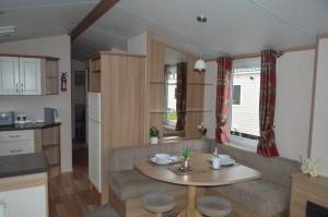 a kitchen and living room with a couch and a table at B4 at The Old Mill Holiday Park in Dyke