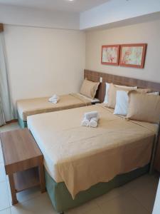 two beds in a hotel room with towels on them at Apart no Hotel Saint Moritz n° 810 in Brasilia