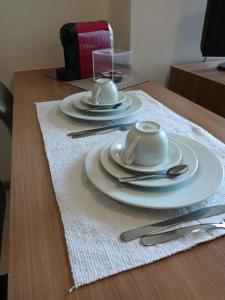 a table with plates and silverware on a wooden table at Apart no Hotel Saint Moritz n° 810 in Brasilia +17 photos