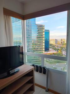 a room with a large window with a view of a city at Apart no Hotel Saint Moritz n° 810 in Brasilia