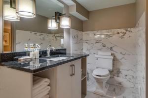 a bathroom with a toilet and a sink and a mirror at Cozy Retreat for 2 Heart of DT Near Broadway in Nashville