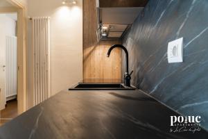 eine Küche mit schwarzer Arbeitsplatte und Spüle in der Unterkunft Maison Amel - Poluc Apartments bilocale in Champoluc
