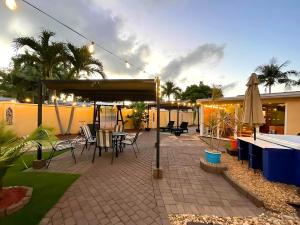 eine Terrasse mit Tisch und Stühlen und einem Sonnenschirm in der Unterkunft Fun Getaway: Hot Tub, Tiki Bar, Arcade Room in Hollywood