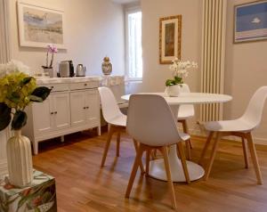 a dining room with a white table and chairs at Casa Bebella in Senigallia
