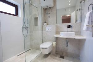 y baño con ducha, aseo y lavamanos. en Villa Makarana Apartments, en Makarska