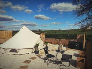 a white tent with chairs and a table at Lodge romantique "le grand chêne" avec Jacuzzi privatif in Lapalisse