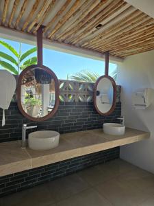 Dos lavabos en un baño con dos espejos en Selanna Full Accommodation for 26 people, en El Paredón Buena Vista
