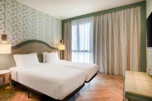 a hotel room with a large bed and a window at AC Hotel Ciudad de Sevilla by Marriott in Seville +39 photos