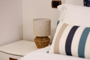 a bedroom with a bed with a lamp on a table at Casa Acqua Marina in Castiglione della Pescaia