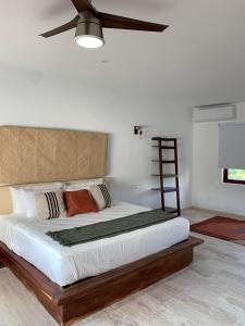 una camera con un grande letto e un ventilatore a soffitto di Luana suites- Suite Koya a Zihuatanejo Altre 25 foto