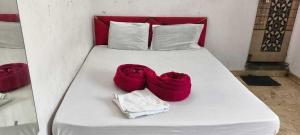 a white bed with two red towels on it at SPOT ON Sunrise Inn in Nagpur +1 photo