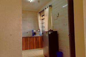 a kitchen with a refrigerator and a window at mama ori apartments in Nairobi