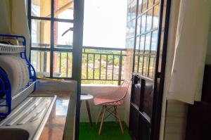 a room with a chair and a window and a table at mama ori apartments in Nairobi
