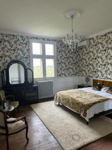 a bedroom with a bed and a chandelier at Chateau La Croix De Millorit in La Reuille +81 photos
