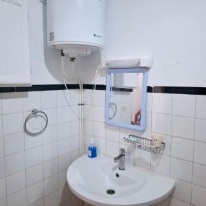 a bathroom with a white sink and a mirror at Maison de plage pied dans l'eau pour familles in El Jadida +47 photos