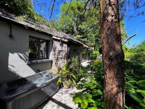 ein Haus mit einem Baum davor in der Unterkunft Beili Glas Cottage in Pontardawe