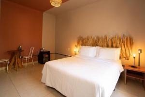 a bedroom with a large white bed with a wooden headboard at The Garden in Bonito