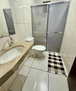 a bathroom with a toilet and a sink and a shower at Ap Conforto no Centro de Sinop in Sinop +5 photos